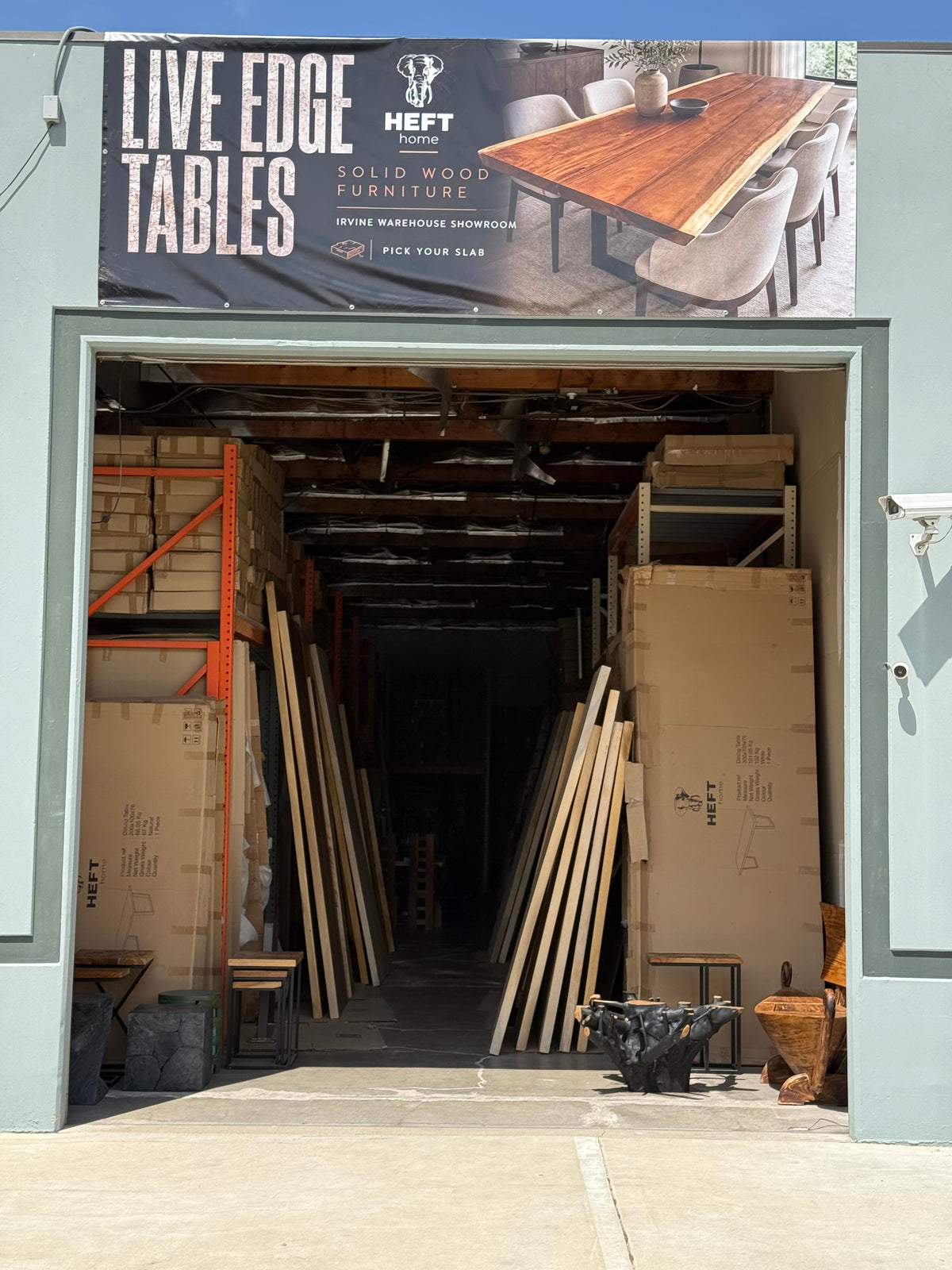 Complete entrance to the HEFT Home Irvine warehouse, with the Live Edge Tables sign and open showroom doorway